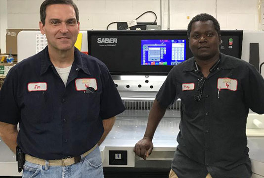 House of Printing employees operating a SABER X-15 paper cutter