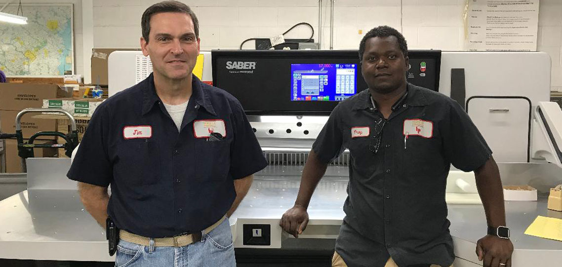 House of Printing employees operating a SABER X-15 paper cutter