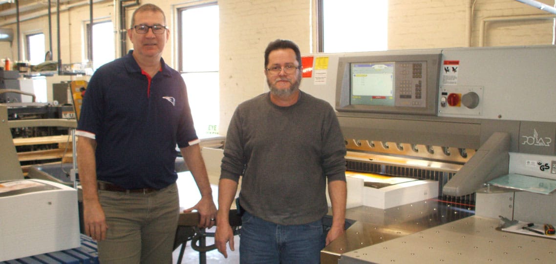 Production manager Tom Reginer (left) and operator Agustin Roque with the Polar X115 paper cutter.