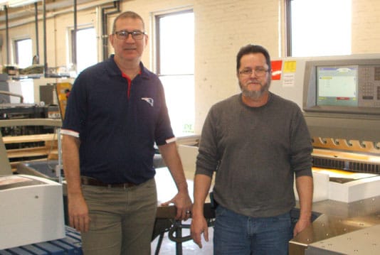 Production manager Tom Reginer (left) and operator Agustin Roque with the Polar X115 paper cutter.
