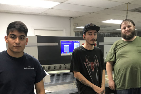 Operators standing with new PRISM paper cutter